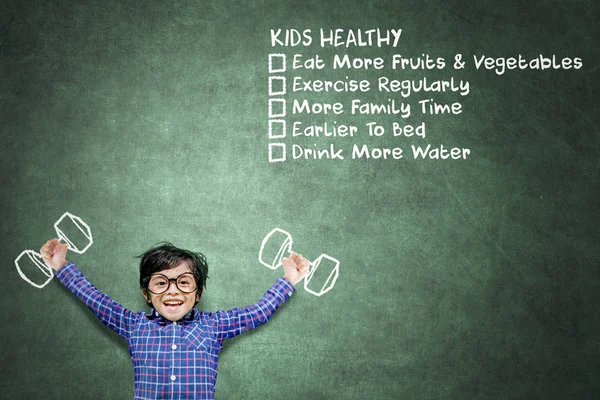 Mutlu küçük çocuk sağlıklı çocuk listeleri yakınında egzersiz — Stok fotoğraf