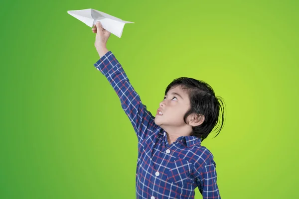 Menino a tocar um avião de papel no estúdio — Fotografia de Stock