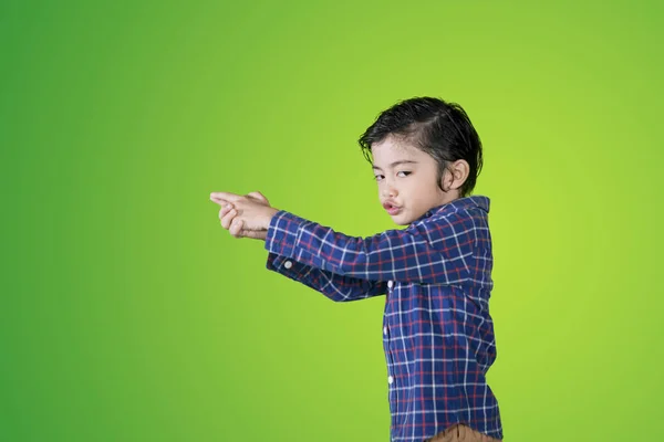 Küçük çocuk stüdyoda parmağıyla silah atışları oynuyor — Stok fotoğraf