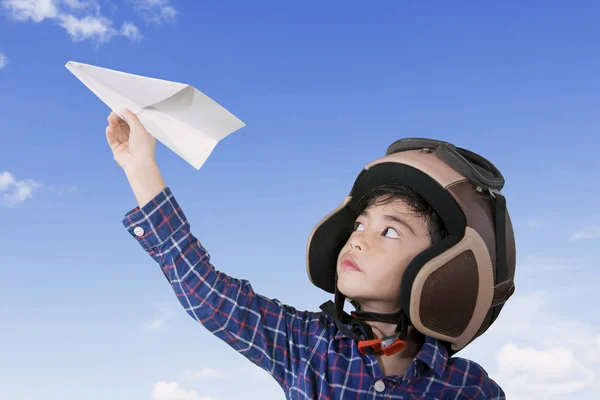 Маленький пилот играет на бумажном самолете — стоковое фото