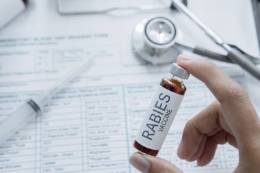 Doktor Kuduz hastalığı için aşı bir şişe tutar