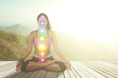 Woman meditating with colored chakra points clipart