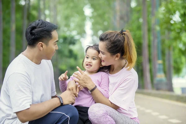 Menina bonito conversando com seus pais no parque — Fotografia de Stock