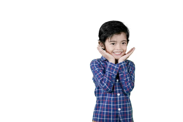 Cute little boy holding his chin in the studio — Stock Photo, Image