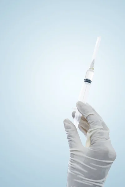 Mãos de médico fêmea segurando uma agulha de injeção — Fotografia de Stock