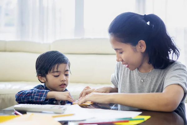 Kleiner Junge bastelt mit seiner Mutter ein Papierflugzeug — Stockfoto