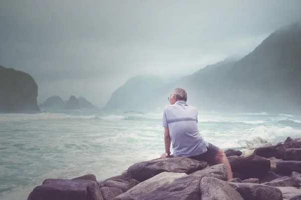 Вид сзади на старика, наслаждающегося видом на пляж Папума — стоковое фото