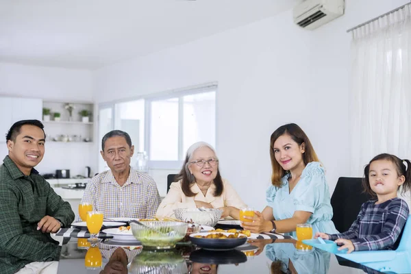 Lachende drie generatie familie met lunch — Stockfoto