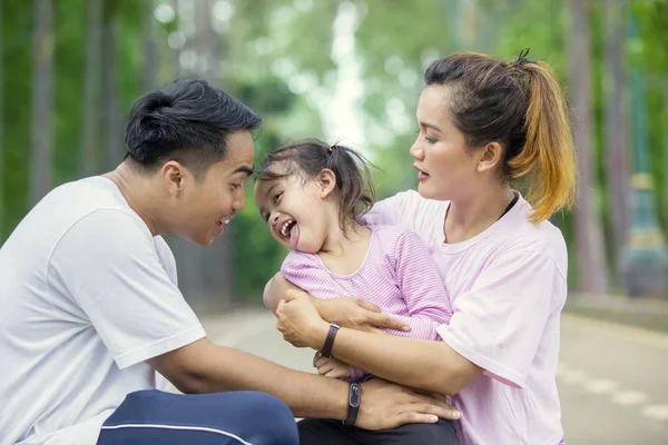 Молодая семья смеется вместе в парке — стоковое фото