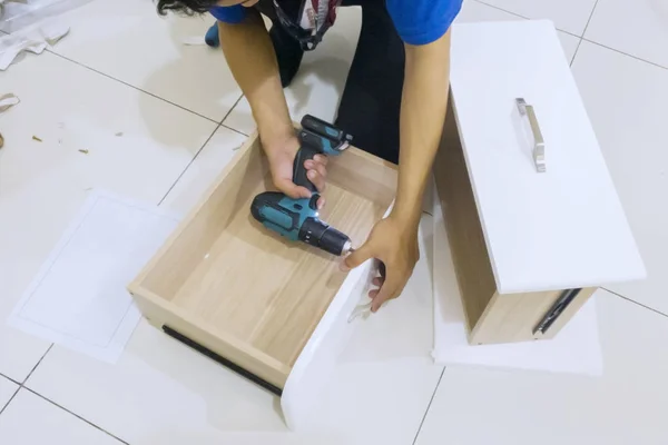 Mãos de carpinteiro instalando uma gaveta com uma broca — Fotografia de Stock
