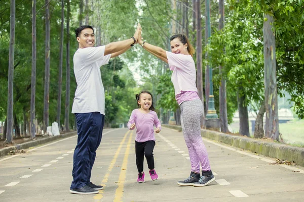 Menina bonito conversando com seus pais no parque — Fotografia de Stock