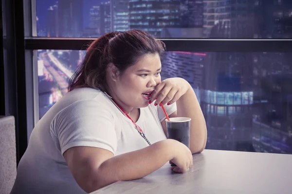Överviktiga kvinnan njuter av ett glas Cola — Stockfoto