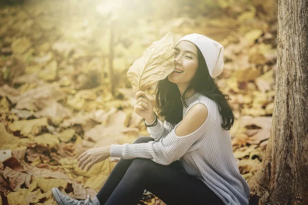 Donna siede al parco autunnale con il cellulare — Foto Stock