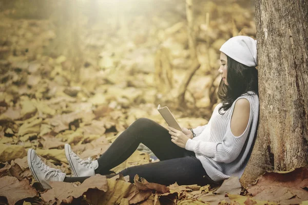 Femme est assis au parc d'automne avec téléphone portable — Photo