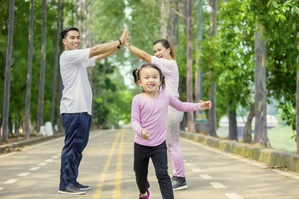 Ragazza carina che chatta con i suoi genitori nel parco — Foto Stock