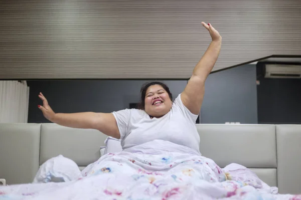 Mulher gorda feliz esticando as mãos depois de acordar — Fotografia de Stock