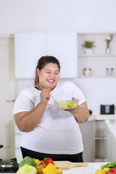 Lycklig feta kvinna äter hälsosam sallad — Stockfoto