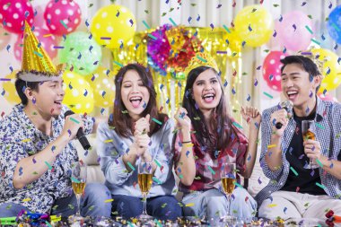 Birlikte şarkı söyleyen iki çift parti veriyor.