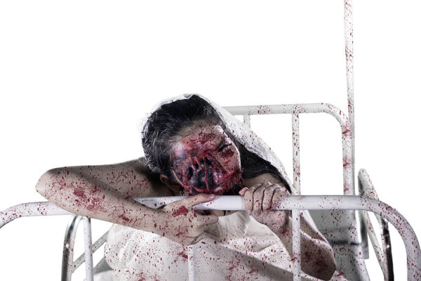 Spooky female ghost wearing bridal gown on the bed