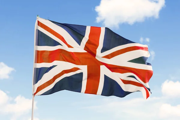 United Kingdom flag blowing under blue sky — Stock Photo, Image