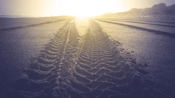 Pistes de pneus sur la plage de sable — Photo