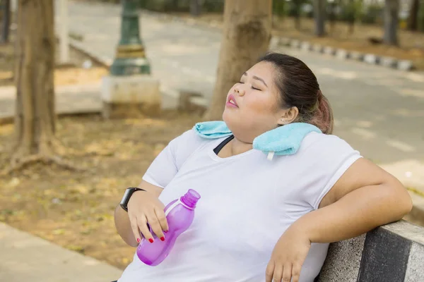 Mulher gorda descansando no parque após o exercício — Fotografia de Stock