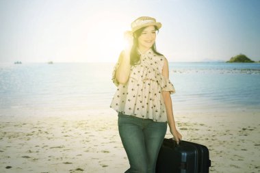 Havaalanında bavulla gülümseyen çekici kadın