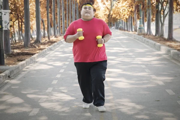 Nadwaga człowiek jogging w Autumn Park — Zdjęcie stockowe