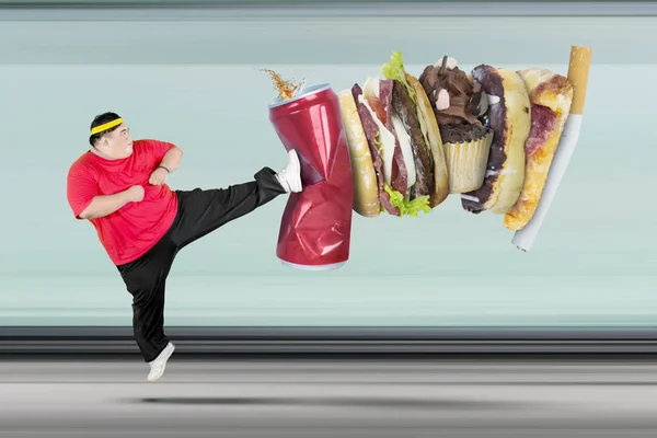 Nadwagą człowiek kopiąc napój bezalkoholowego i Fast food — Zdjęcie stockowe