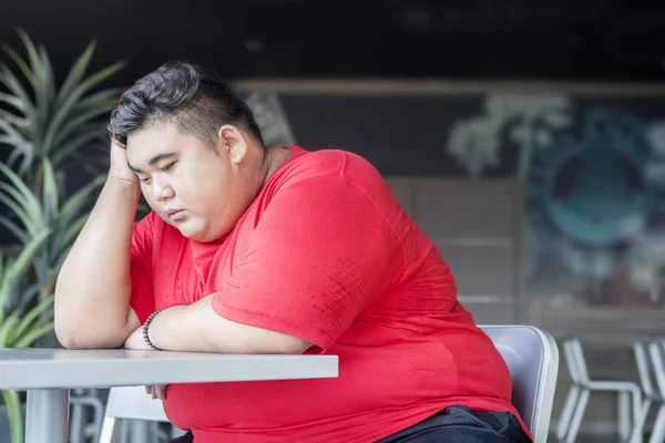 Übergewichtiger Mann sieht im Restaurant verzweifelt aus — Stockfoto