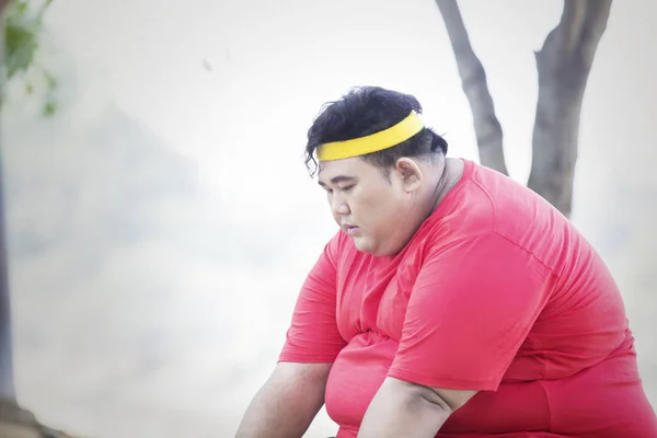 Homme en surpoids semble fatigué dans le parc — Photo