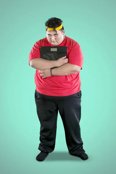 Young fat man looks tired after exercises on studio — Stock Photo, Image