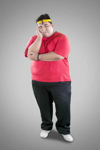 Young fat man looks tired after exercises on studio — Stock Photo, Image