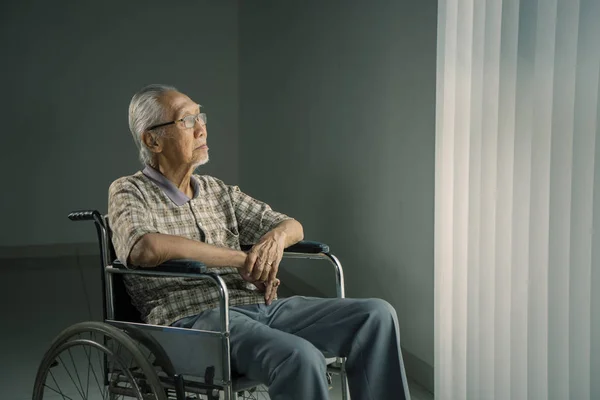Homme âgé pensant à quelque chose dans un fauteuil roulant — Photo