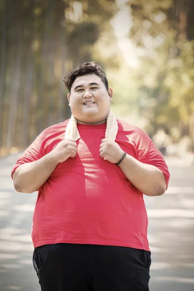 Young fat man looks tired after exercises on studio — Stock Photo, Image