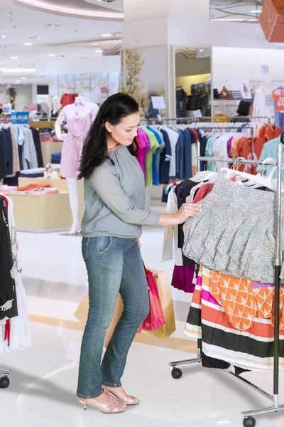 Kvinna köpa och välja kläder på mall — Stockfoto