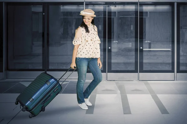 Woman walking in the train station with luggage — Stok fotoğraf