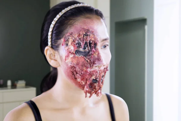 Mujer joven haciendo maquillaje de cara de horror en el estudio — Foto de Stock