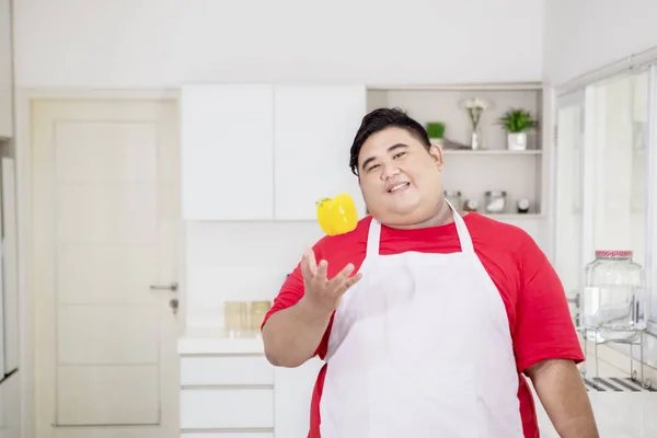 Ung fet man kastar en paprika på handen — Stockfoto