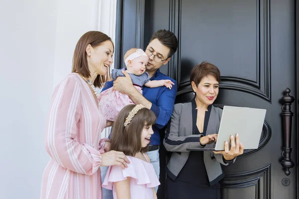 Feliz vendedora mostrando chaves com seus clientes — Fotografia de Stock