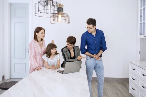Ung familj konsulterar ett nytt hus med sin agent — Stockfoto