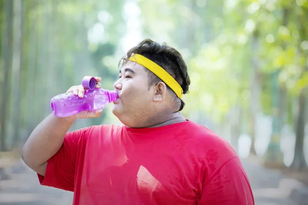 Homme gras fatigué boire de l'eau après l'exercice — Photo