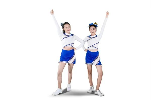 Due cheerleader che alzano la mano su studio — Foto Stock