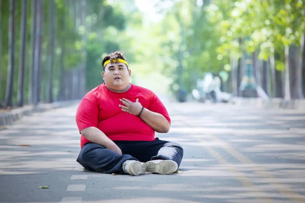Young fat man having heart pain after running — Stock Photo, Image