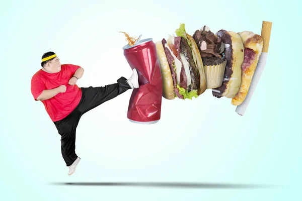 Młody gruby człowiek kopiąc napój bezalkoholowy i Fast food — Zdjęcie stockowe