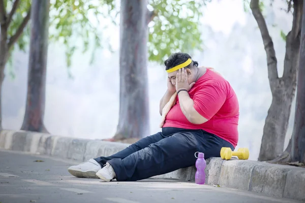 Jovem gordo parece triste após o exercício no parque — Fotografia de Stock