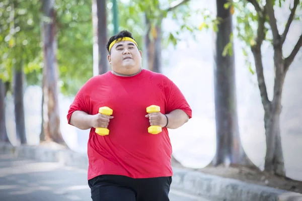 Asiatique gros homme courir avec haltères dans le parc — Photo