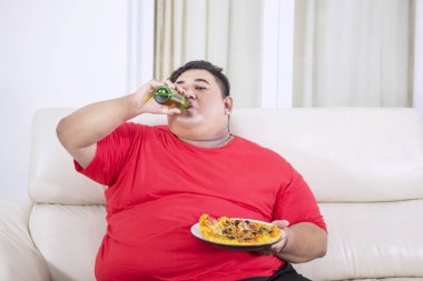 Kilolu adam bira içer ve pizza yer