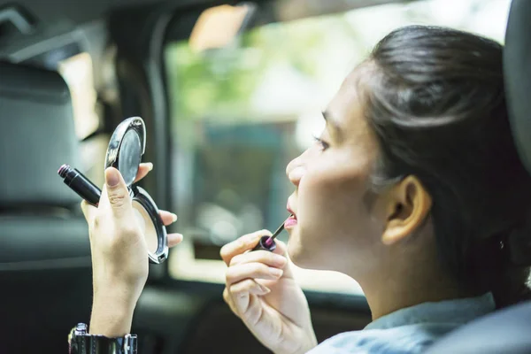 Empresária aplicando batom em seus lábios no carro — Fotografia de Stock
