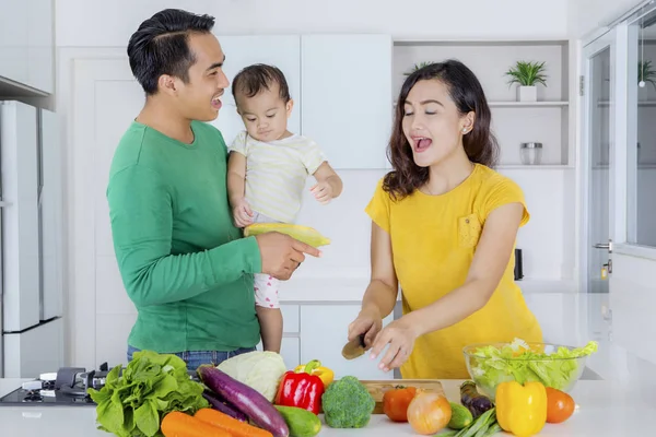 Glückliche Familie macht Gemüsesalat in der Küche — Stockfoto